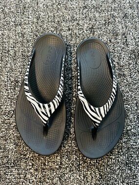 OOFOS Women's Black Flip Flops with White Zebra Strap